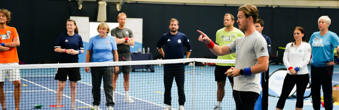 Ashley Neaves coaching a group of players on court